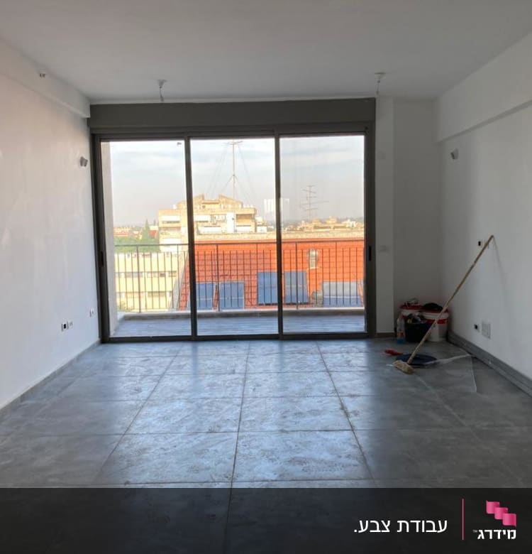 חדר עם קירות צבועים, דלי ומברשת על הרצפה